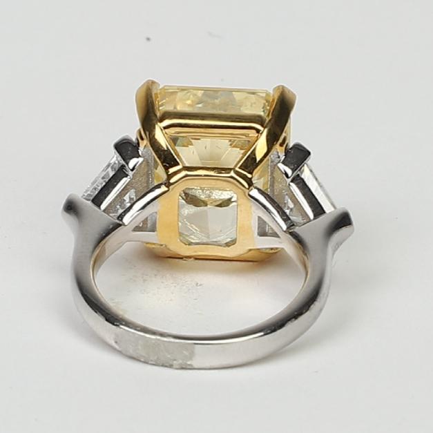 A close-up of the DiamondVeneer Fashion Three Stones Cubic Zirconia Engagement Ring (803R100), featuring a two-tone sterling silver band with a large rectangular yellow stone in a gold setting and two smaller clear stones from the back view.