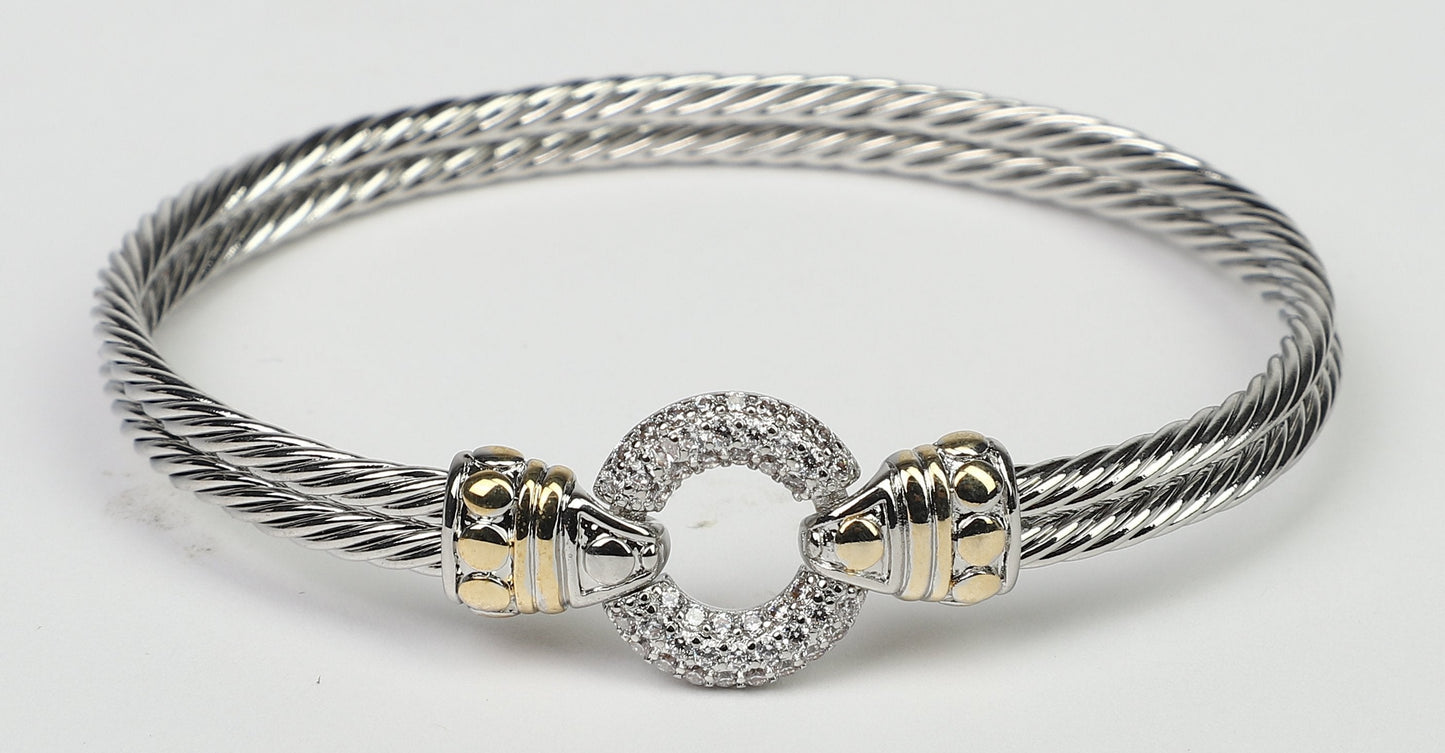 The DiamondVeneer Fashion Circle Zirconite Cubic Zirconia Pave Cable 2-tone Bangle Bracelet (500B3961) features gold-tone accents and a circular, pave-set centerpiece in a twisted design on a white background.