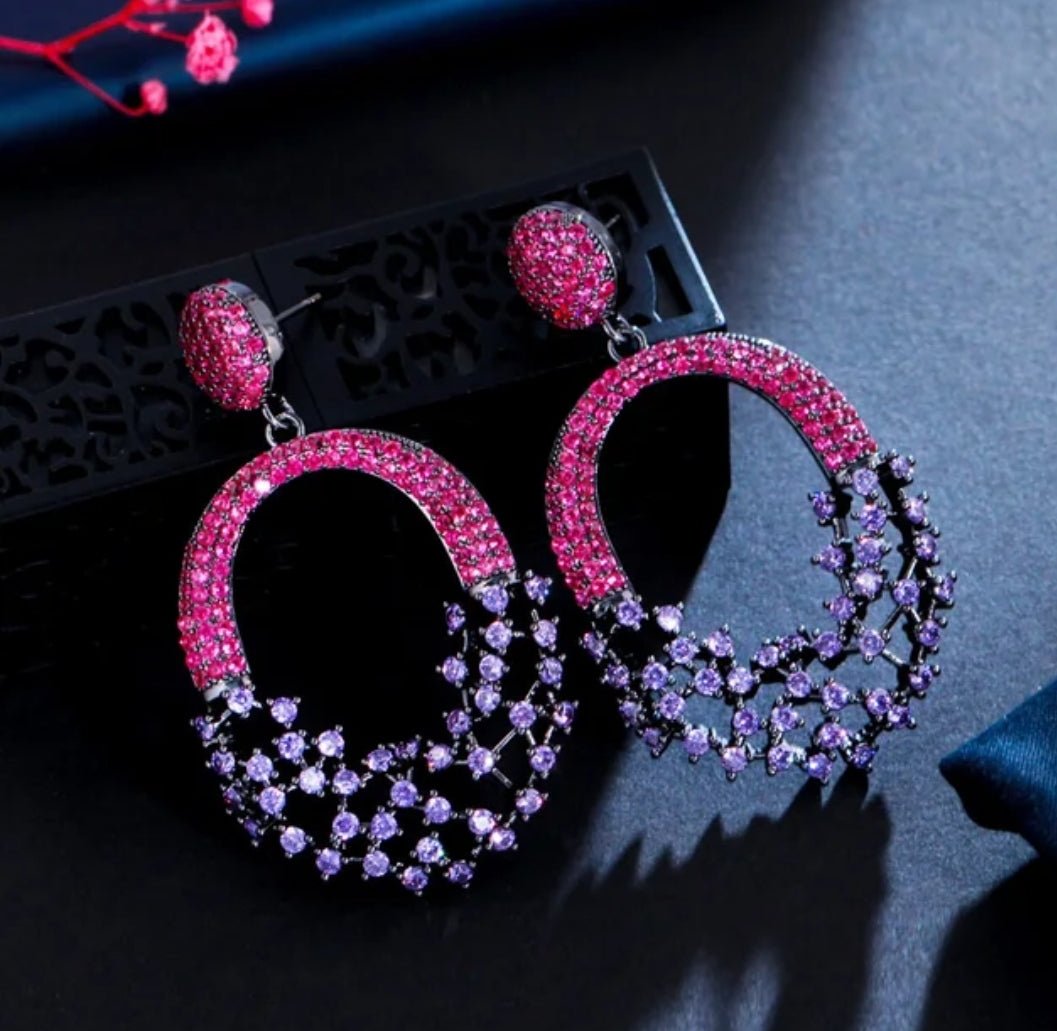 DiamondVeneer Fashion Chandeliers Earrings Zirconite Cubic Zirconia 826E20: Elegant oval-shaped earrings with pink and purple cubic zirconia in a gradient floral design, displayed on a dark background.