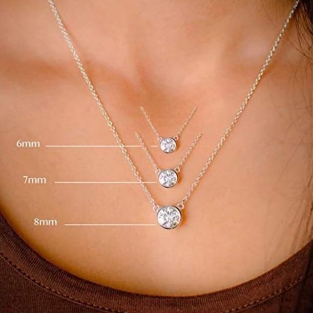 Close-up of silver necklaces with 6mm, 7mm, and 8mm round pendants on a person’s neck, each pendant size labeled for comparison.