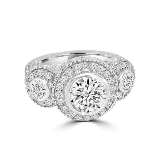 The DiamondVeneer Fashion Three Stones Cubic Zirconia Engagement Ring 635R13665 features three round stones in halo settings with sparkling accents and intricate band detailing.