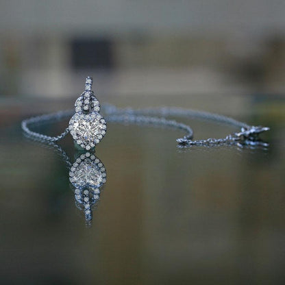 The DiamondVeneer Fashion 1CT Heart Diamond Veneer Cubic Zirconia Pendant (635P10779A) features a heart-shaped cubic zirconia set on a delicate chain, sparkling elegantly as it rests on a reflective surface.