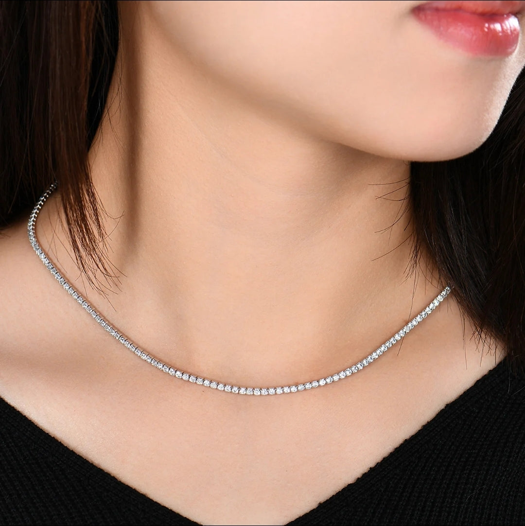 A close-up of a woman wearing the Zirconmania Round Cubic Zirconia Tennis Necklace (Zirconite 602N50005). She has straight dark hair and a black top—a sparkling, elegant jewelry gift for women.