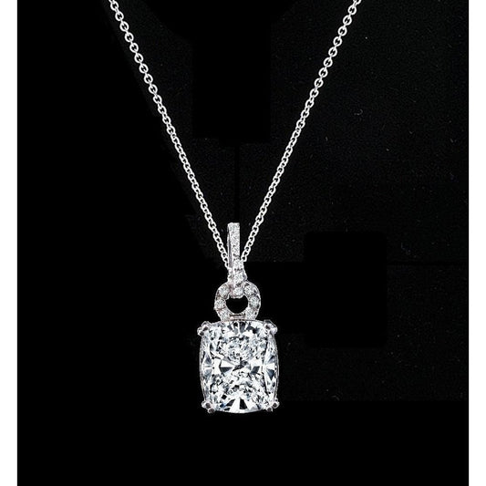 The DiamondVeneer Fashion 5CT Cushion Diamond Veneer Cubic Zirconia Pendant (635P10784) features a sparkling cushion-cut stone on a thin chain, accented by a loop of smaller stones, set against a black background.