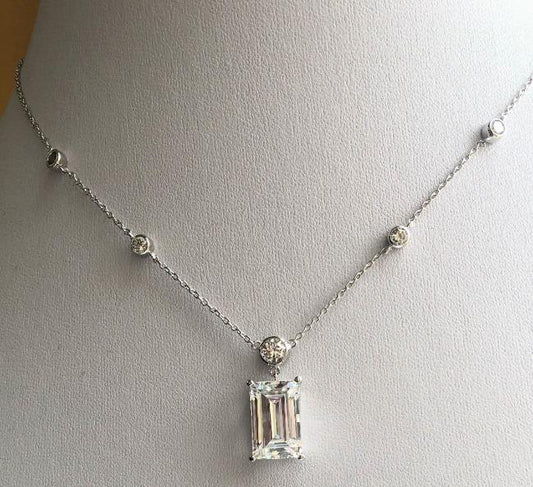 The DiamondVeneer Fashion 6 CT Emerald Diamond Veneer Sterling Silver Pendant (635P50173) features five small round diamond veneer accents along the chain and a striking emerald-cut cubic zirconia centerpiece, displayed on a white bust.