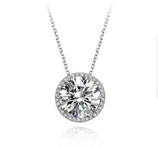 The DiamondVeneer Fashion Round Diamond Veneer Cubic Zirconia Pendant (635P15708) is a silver chain necklace with a large round-cut cubic zirconia surrounded by smaller clear stones, shown on a white background.