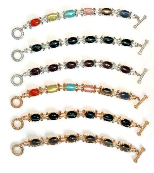 Five DiamondVeneer Fashion Cats Eye Oval Cabochon set w/Zirconite Cubic Zirconia Bracelet 501B097 pieces are arranged in parallel on a white background, each with metal links, toggle clasps, and one 18K Gold option.