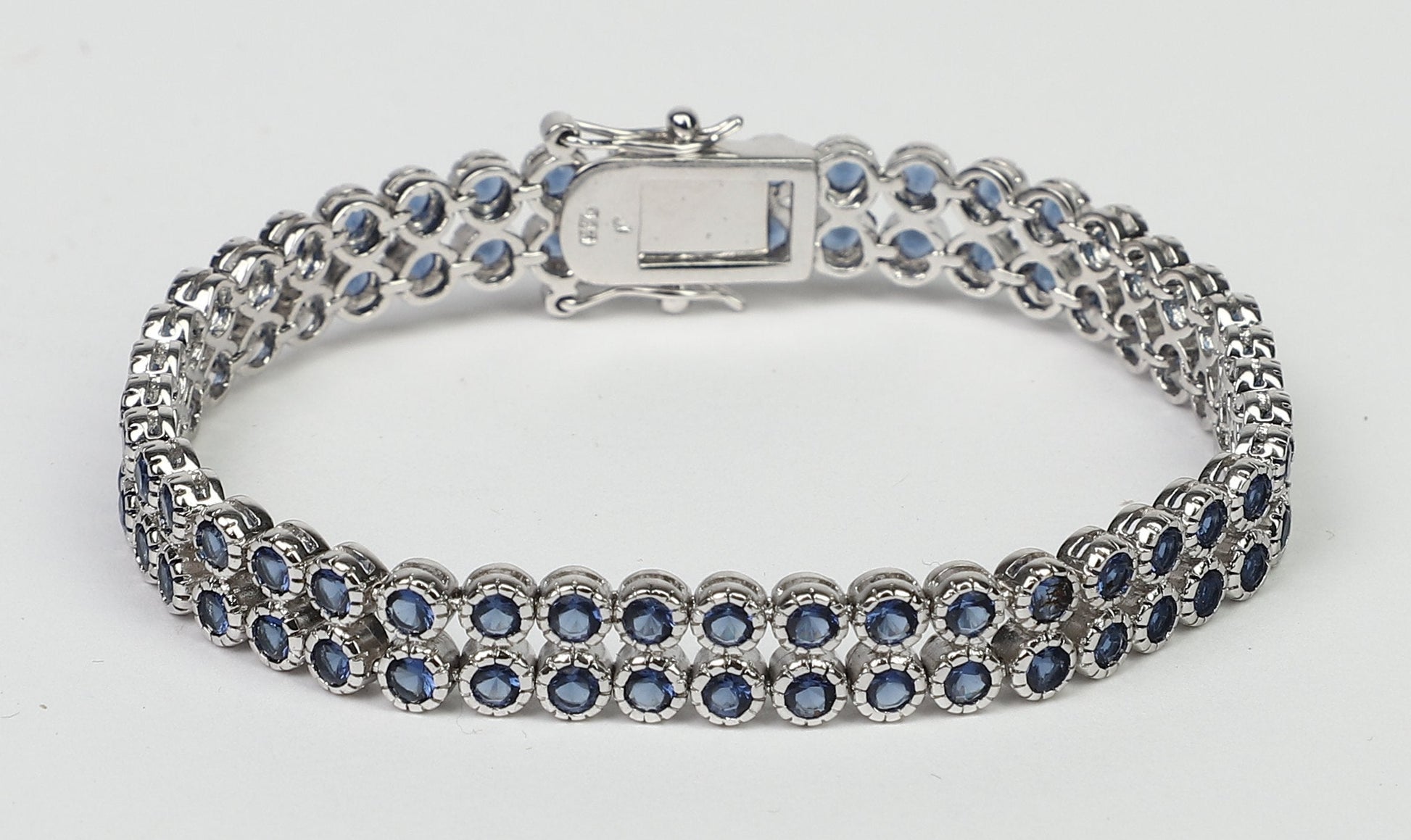 The DiamondVeneer Fashion AH3559 bracelet features two rows of color Zirconite cubic zirconia in a sterling silver setting with a double safety lock, shown in a closed loop on a plain white background.