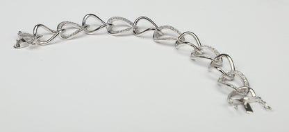 The DiamondVeneer Fashion Large Curved Link Zirconite Cubic Zirconia Sterling Silver Bracelet (STB599) features interlocking heart-shaped and curved links, some accented with sparkling cubic zirconia, shown on a plain white background.
