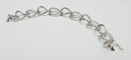 The DiamondVeneer Fashion Large Curved Link Zirconite Cubic Zirconia Sterling Silver Bracelet (STB599) features interlocking heart-shaped and curved links, some accented with sparkling cubic zirconia, shown on a plain white background.