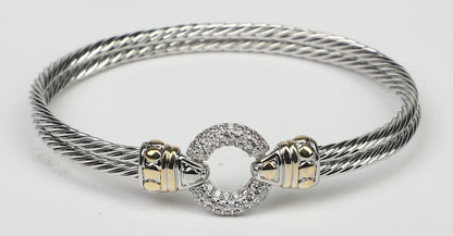 The DiamondVeneer Fashion Circle Zirconite Cubic Zirconia Pave Cable 2-tone Bangle Bracelet (500B3961) features gold-tone accents and a circular, pave-set centerpiece in a twisted design on a white background.