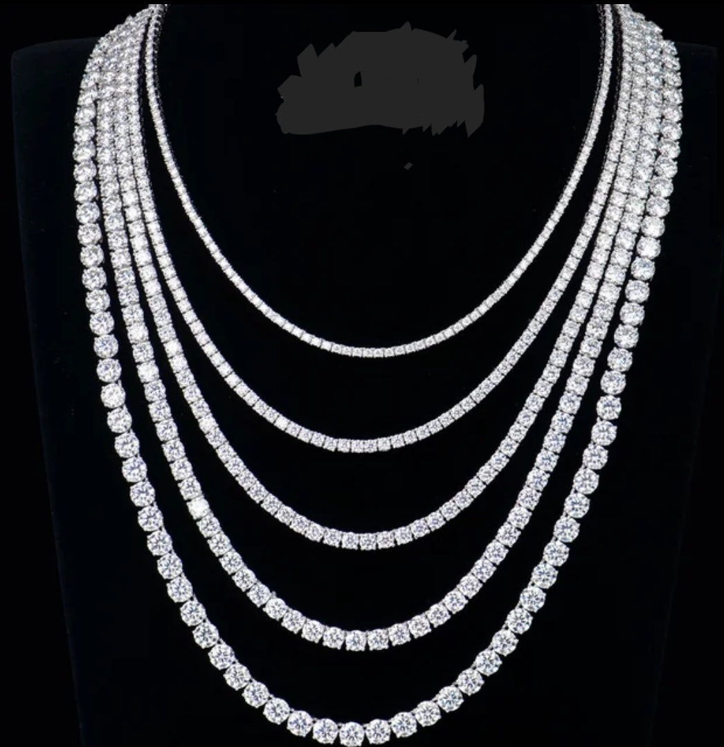 A black display bust showcases six Moissanite Lab Created Diamond Tennis Necklaces by DiamondVeneer Fashion (850N4MM), elegantly layered in graduated lengths—an eye-catching, sparkling alternative to traditional diamonds.
