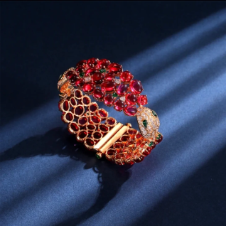 The DiamondVeneer Fashion Luxury Ruby Cabochon Snake Bracelet Bangle zirconite 840B features red stones and a snake-head clasp with white and green gems, showcased on a dark blue background—an ideal statement piece for fashion jewelry lovers.