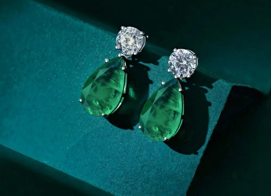 Woman with wet wavy hair in plaid blazer models Zirconmania pear drop cubic zirconia earrings against plain light background.