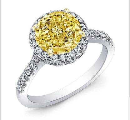 The DiamondVeneer Fashion Round Cubic Zirconia Halo Engagement Ring 800R70/2 in white gold features a large yellow stone surrounded by dazzling cubic zirconia and additional stones along the band for enhanced brilliance.