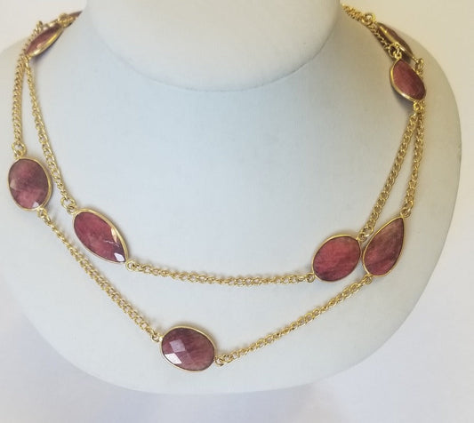 The DiamondVeneer Fashion Gem Stations Necklace (Final Sale, 678nx7) features two layered gold strands with large oval and teardrop-shaped dyed ruby faceted beads, displayed on a white mannequin bust.
