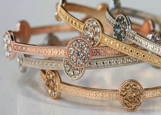 The DiamondVeneer Fashion Zirconite Set of Three Fashion Bangle Bracelets 657B3411 includes gold, rose gold, and silver bangles with circular designs and sparkling clear gemstones—perfect for stacking affordable luxury on your wrist.