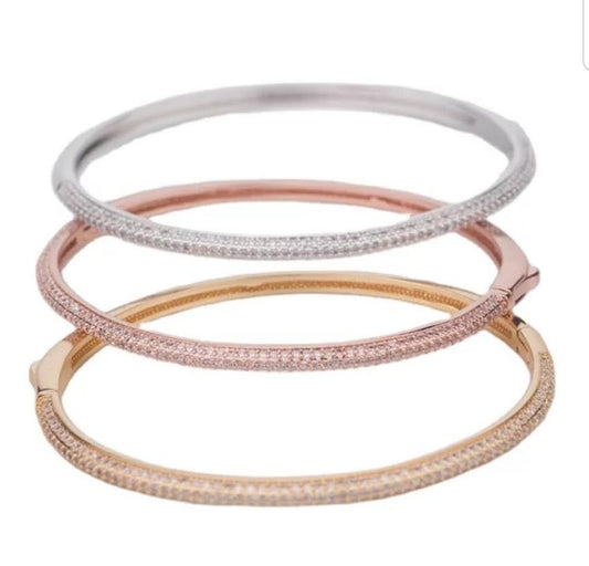 The DiamondVeneer Fashion Stainless Steel Zirconite Cubic Zirconia Bangle Bracelet (812B0270) features three slim bangles in silver, rose gold, and yellow gold tones, each accented with sparkling stones for a stunning stacked look.