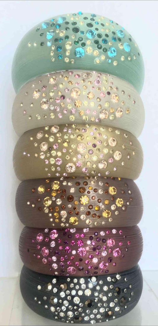 Stacked vertically, six DiamondVeneer Fashion Zirconite Jeweled Acrylic Opaque Bangle Bracelets (629B81361) in assorted shades feature clusters of vibrant rhinestones for a bold, colorful look.