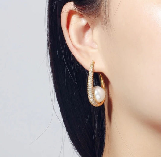 A woman’s ear is shown wearing DiamondVeneer Fashion Zirconite Cubic Zirconia & Pearl Hoop Earrings (826E09), with her straight, dark hair tucked behind her ear against a plain, light background.