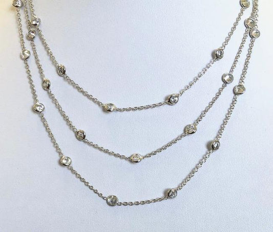 The Cubic Zirconia Multi Strand 14K Gold Pendant Necklace by DiamondVeneer Fashion features three delicate layers with evenly spaced round clear stones, shown on a white background. Model: Diamond Veneer 635NZBYX3K.