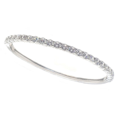 The DiamondVeneer Fashion 4mm Hinged Zirconite Cubic Zirconia Line Rhodium Bangle Bracelet (698B005) features a slim, elegant design with sparkling white stones set in a row, photographed on a plain white background.