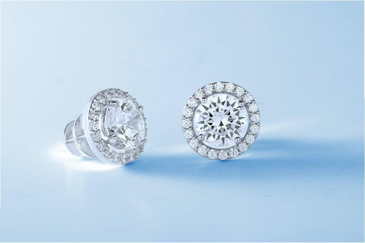 DiamondVeneer Fashion Diamond Veneer Cubic Zirconia halo post Earrings (635E15708) feature a round center stone with a sparkling halo, set in platinum plated metal, shown against a light blue background.