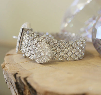 Wide pink cubic zirconia buckle bracelet by Zirconmania, sparkling with crystals, stands out on wood for its bold, luxe design.