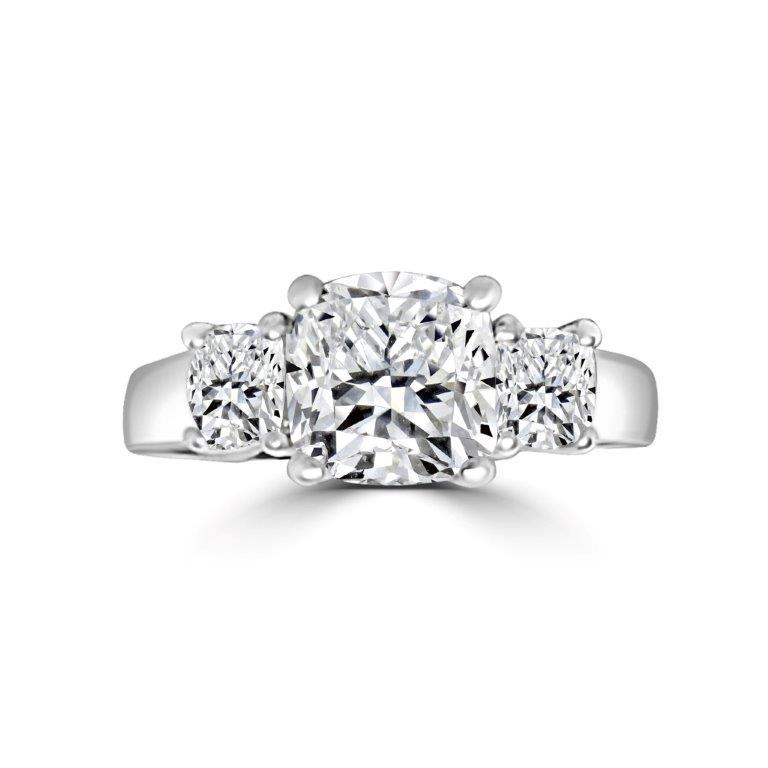 The DiamondVeneer Fashion Three Stone Cushion Diamond Veneer Cubic Zirconia 14K Gold Ring (635R0010K) features a cushion-cut center stone flanked by two round stones on a polished gold band.