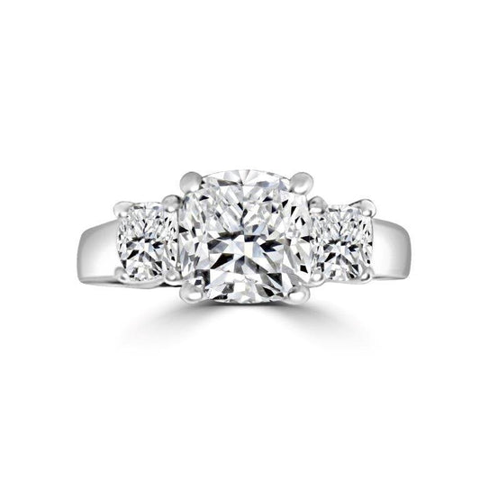 The DiamondVeneer Fashion Three Stone Cushion Diamond Veneer Cubic Zirconia 14K Gold Ring (635R0010K) features a cushion-cut center stone flanked by two round stones on a polished gold band.