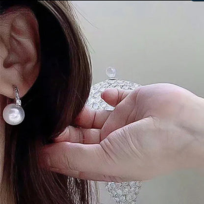 White pearl and cubic zirconia huggie earrings by Zirconite, worn on model, 851E2949